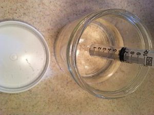syringe in jar of liquid